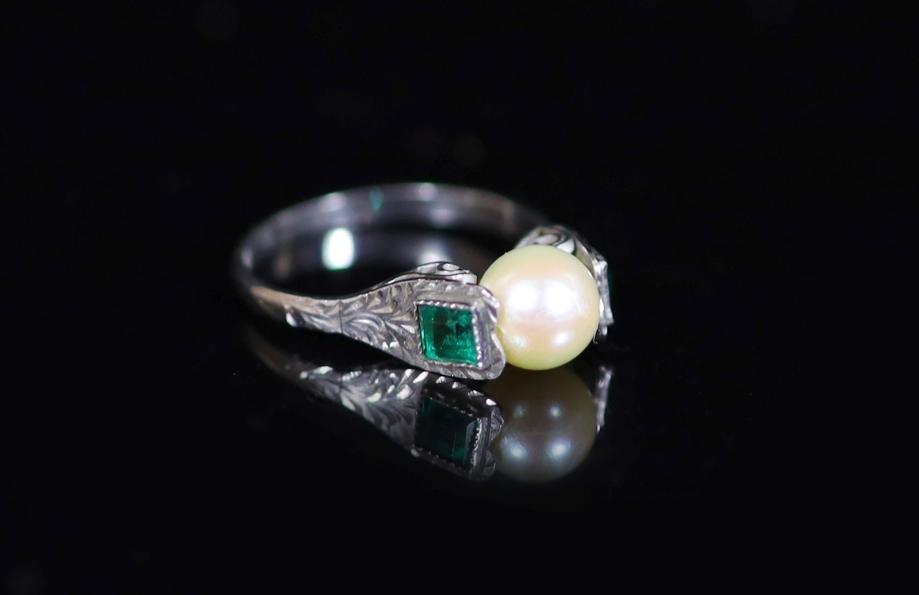 A mid 20th century white gold, cultured pearl and emerald set three stone ring